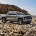 A silver 2023 Chevy Colorado Z71 is shown from the side parked on a rocky beach.