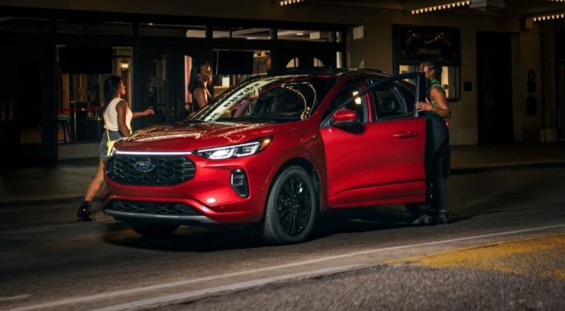People are shown getting into a red 2023 Ford Escape ST-Line Elite.