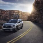 A silver 2023 Honda CR-V Sport Touring is shown from the front on a sunny day.