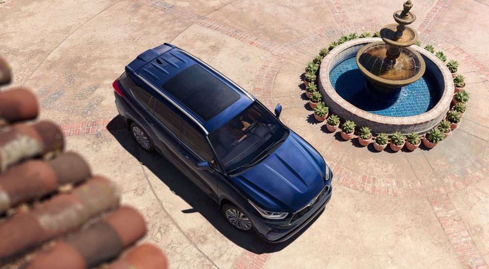 A blue 2023 Toyota Highlander Platinum is shown from a high angle next to a fountain.