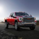 A red 2023 GMC Sierra 2500HD is shown from the front at an angle.
