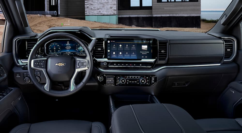The black interior of a 2024 Chevy Silverado 2500HD is shown from the drivers seat.
