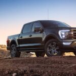 A black 2023 Ford F-150 is shown from the front at an angle after leaving a dealer that has used Ford trucks for sale.