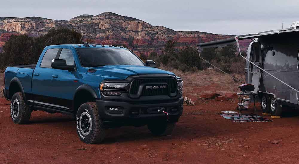 A blue 2023 Ram 2500 Power Wagon is shown from the front at an angle during a 2023 GMC Sierra 2500 HD vs 2023 Ram 2500 comparison.
