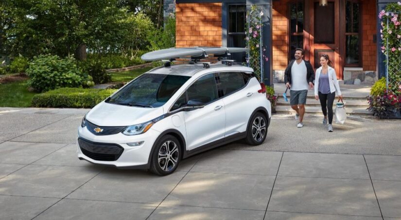 A white 2020 Chevy Bolt EV is shown parked on a driveway after leaving a Chevrolet dealer.