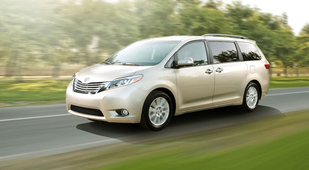 A beige 2017 Toyota Sienna is shown from the side after leaving a used Toyota dealer.