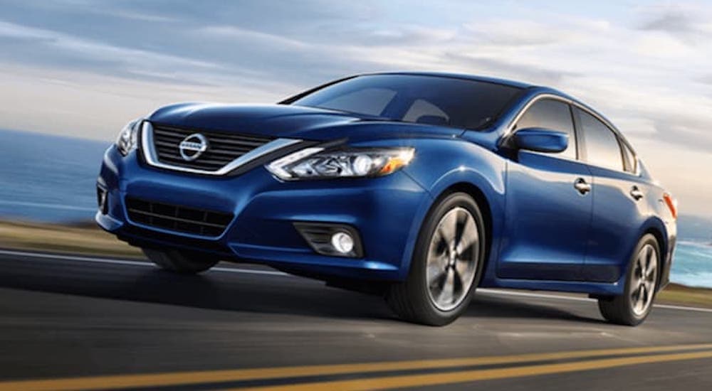 A blue 2018 Nissan Altima is shown from the front at an angle after leaving a dealer that handles Nissan Altima sales.