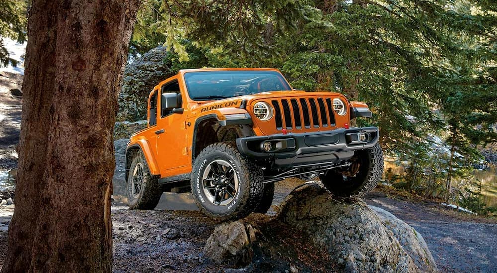 An orange 2019 Jeep Wrangler Rubicon is shown from the front after leaving a used Jeep dealership.