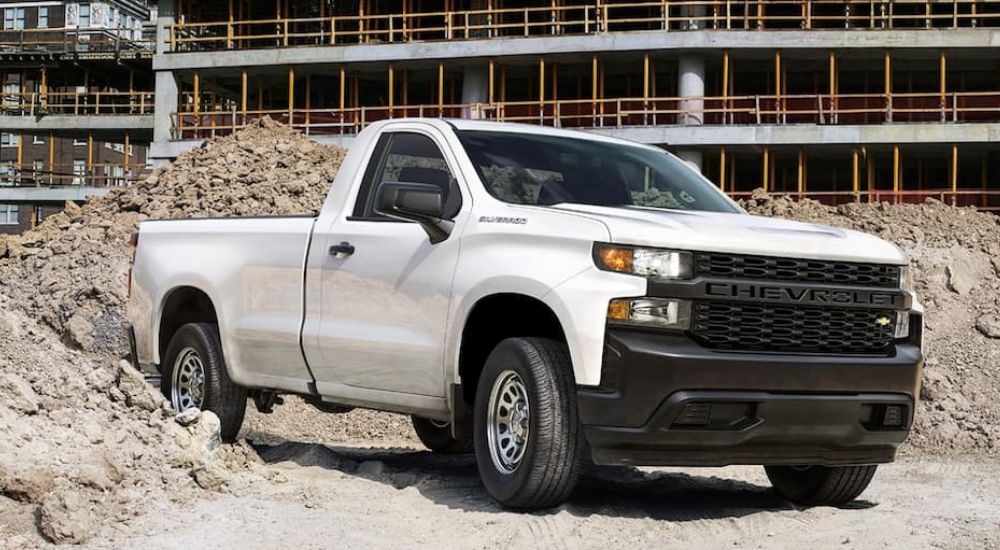 A white 2020 Chevy Silverado 1500 Work Truck is shown at a construction site. 
