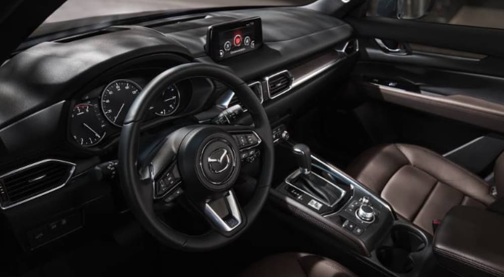 The brown interior of a 2020 Mazda CX-5 is shown from the driver's window.