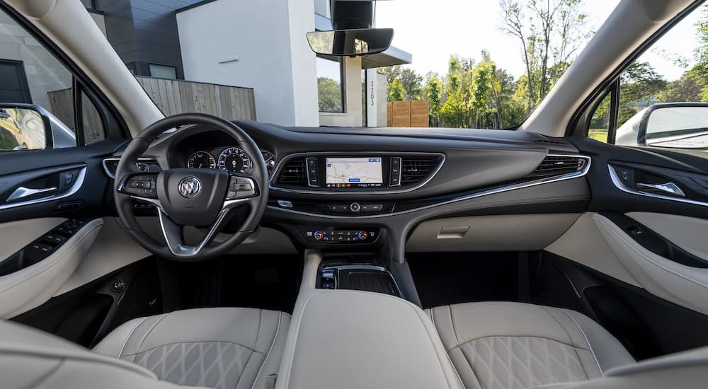 The white interior of a 2023 Buick Enclave Avenir is shown from above the center console.