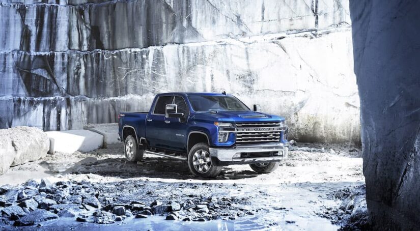 A blue 2023 Chevy Silverado 2500 HD is shown from the front at an angle during a 2023 Chevy Silverado 2500 HD vs 2023 Nissan Titan XD comparison.