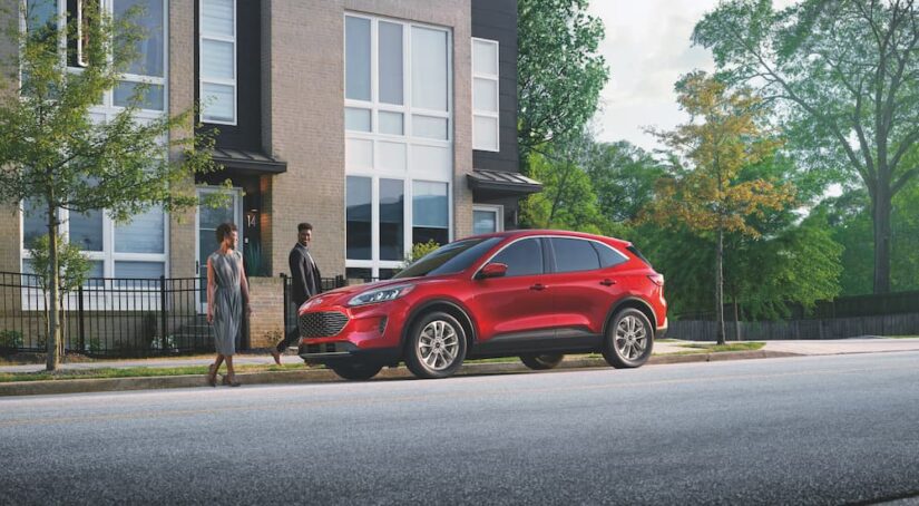 A red 2022 Ford Escape is shown from the side on a city street after leaving a dealer that has a Ford Escape for sale.