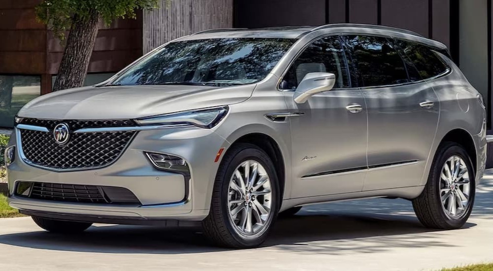 A silver 2023 Buick Enclave Avenir is shown parked in a driveway.