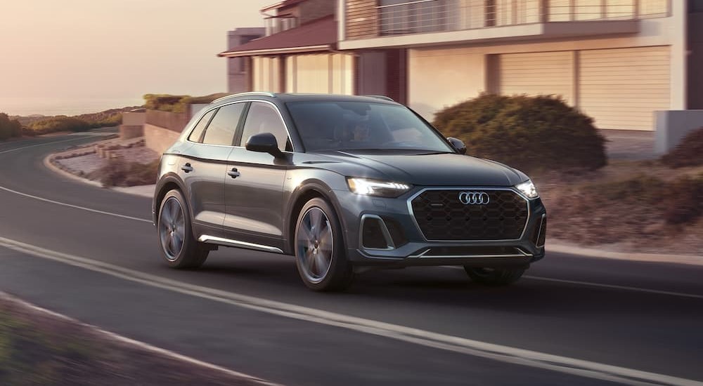 A gray 2023 Audi Q5 is shown driving on a highway.