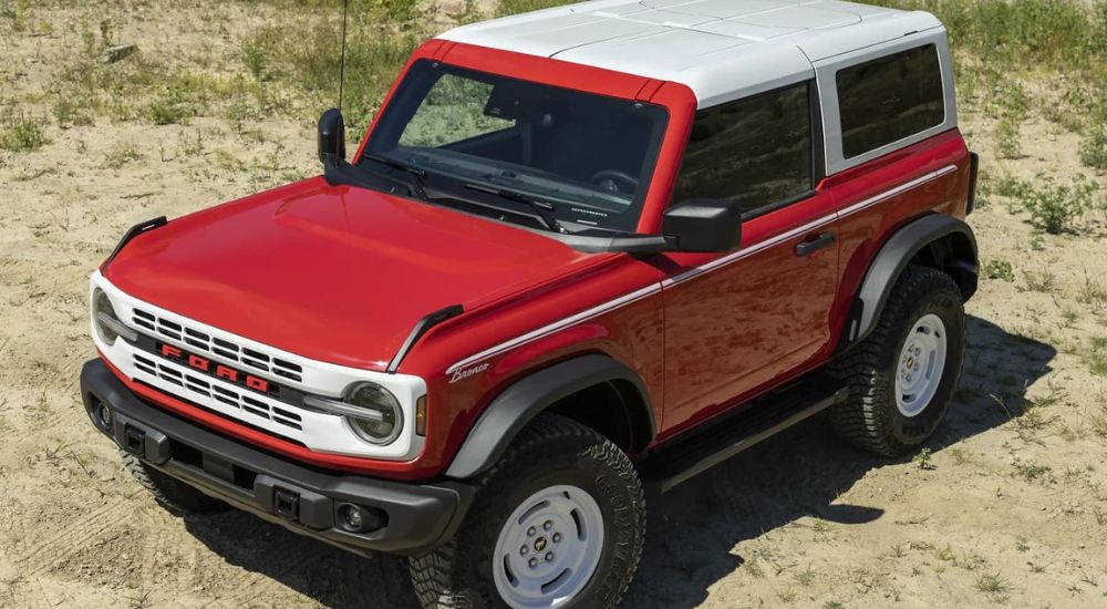 A red 2023 Ford Bronco Heritage Edition is shown parked in the desert. 