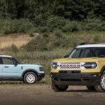 A Robin Egg's Blue 2023 Ford Bronco Sport Heritage Edition and a yellow Heritage Limited Edition are shown parked in a field.
