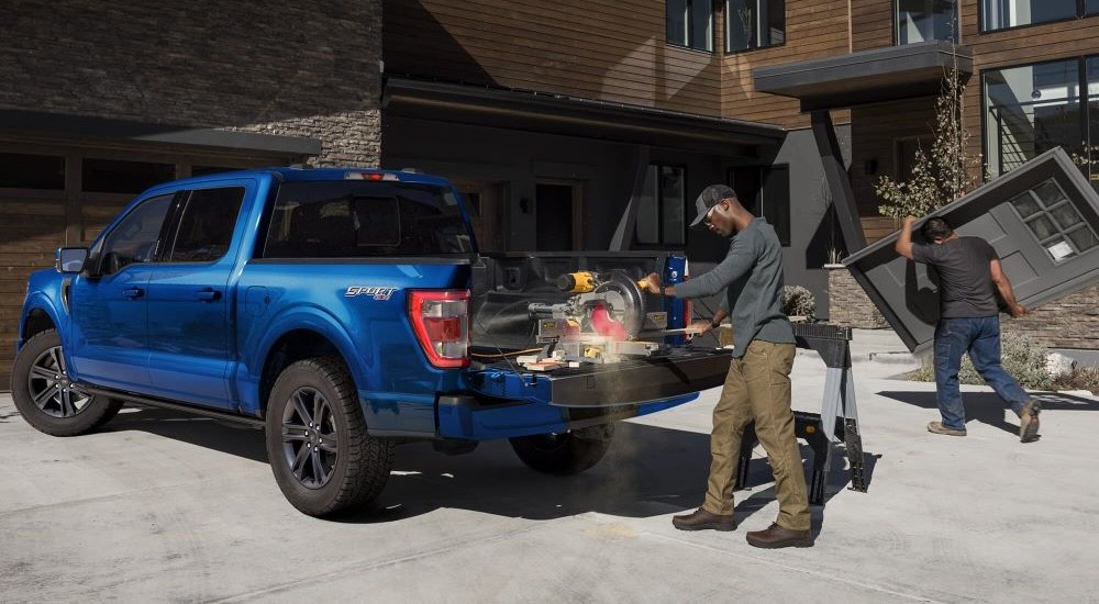 A blue Ford F-150 Sport is shown parked on a driveway.