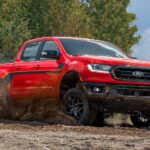 A red 2023 Ford Ranger Splash Edition is shown accelerating on a muddy trail.