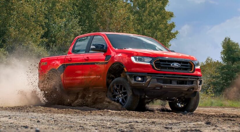 A red 2023 Ford Ranger Splash Edition is shown accelerating on a muddy trail.