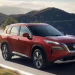 A red 2023 Nissan Rogue is shown from the front at an angle during a 2023 Nissan Rogue vs 2023 Toyota RAV4 comparison.