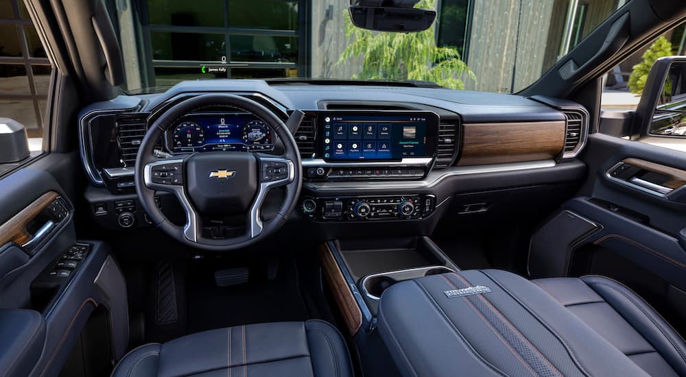 The black interior of a 2024 Silverado 2500 HD High Country is shown from the driver's seat.