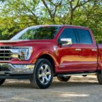 A red 2023 Ford F-150 Lariat is shown from the front at an angle.