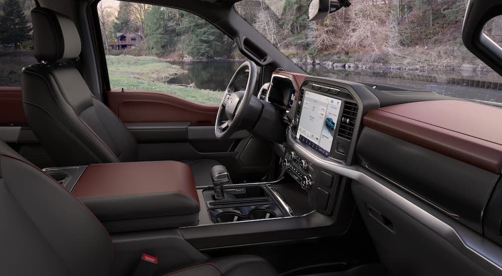 The black and brown interior of a 2023 Ford F-150 Lariat is shown from the passenger seat.