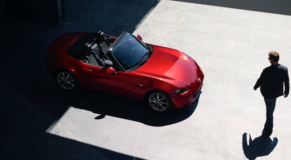 A red 2023 Mazda MX-5 Miata Roadster is shown parked.