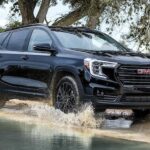 A popular vehicle for GMC Terrain sales, a black 2023 GMC Terrain SLT, is shown off-roading.