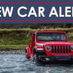 A red 2023 Jeep Wrangler is shown under a new car alert banner.