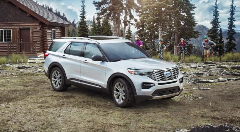 A white 2021 Ford Explorer is shown in front of a cabin after leaving a used Ford dealer.