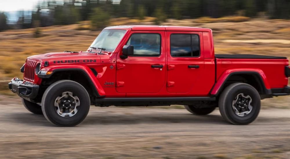 A red 2020 Jeep Gladiator is shown on the road after leaving a used Jeep dealer.