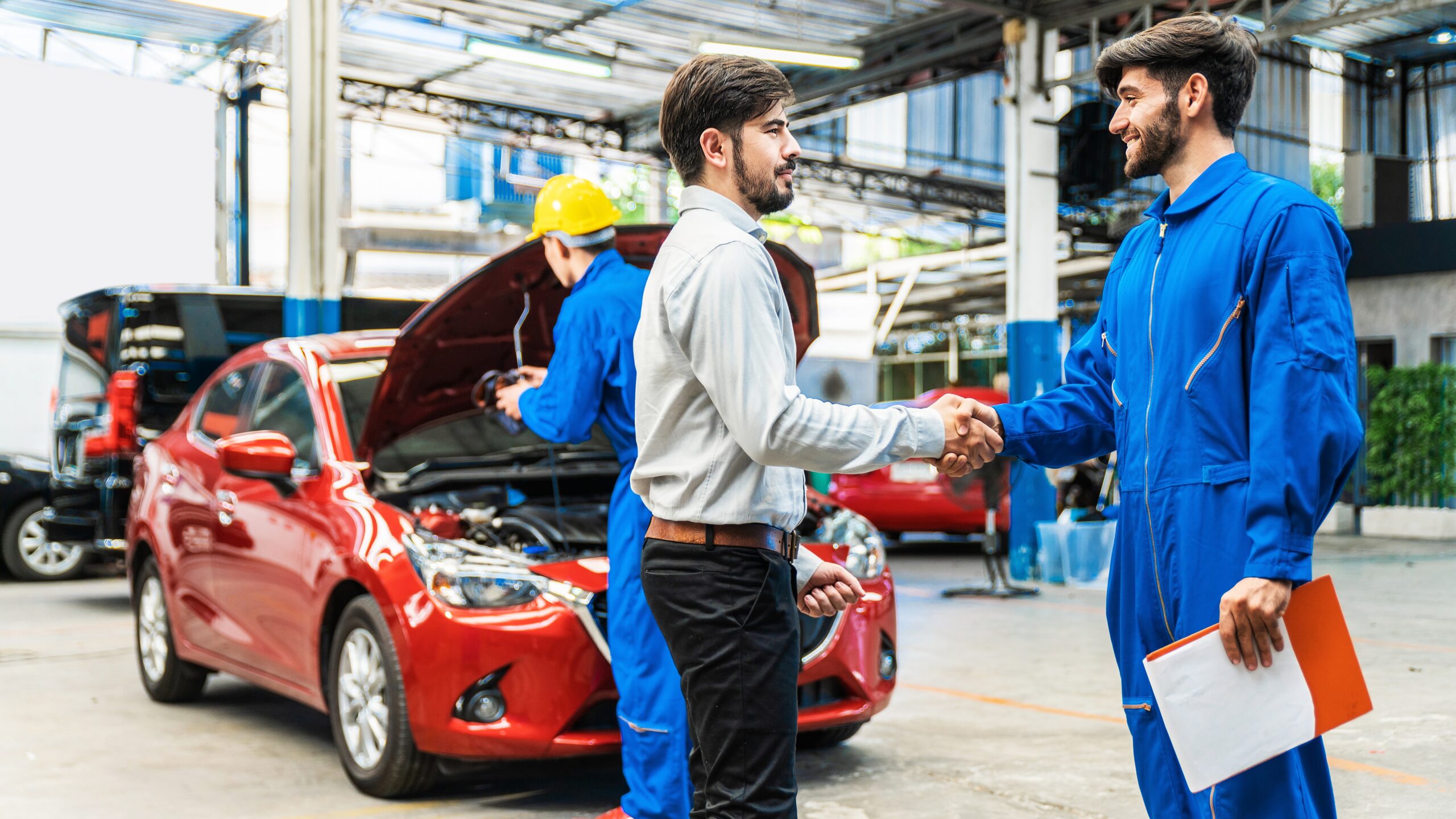 A mechanic is shown shaking hands with a consumer after the vehicles safety checks were completed.