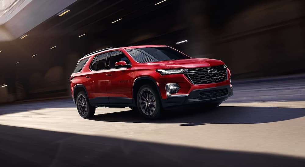 A red 2023 Chevy Traverse RS is shown from the side while on the highway.