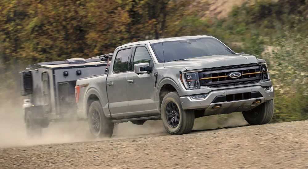 A gray 2023 Ford F-150 Tremor is shown towing a trailer.