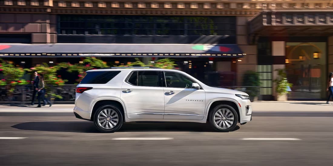 A white 2023 Chevy Traverse is shown driving on a road.