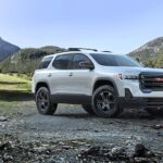 A white 2023 GMC Acadia is shown from the side after winning a 2023 GMC Acadia vs 2023 Honda Pilot comparison.