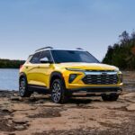 A yellow 2024 Chevy Trailblazer Activ is shown parked beside a lake.