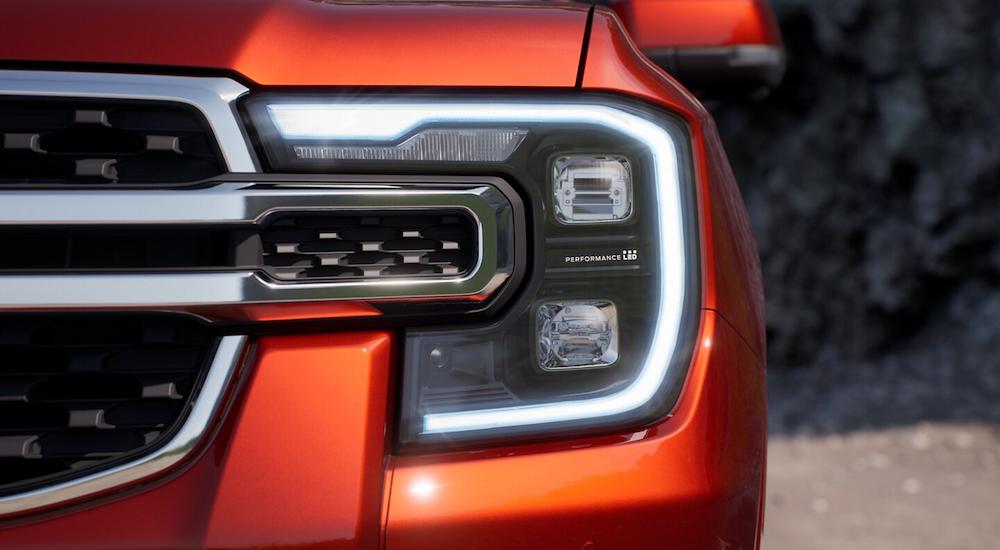 A close up of the headlight on an orange 2024 Ford Ranger is shown.