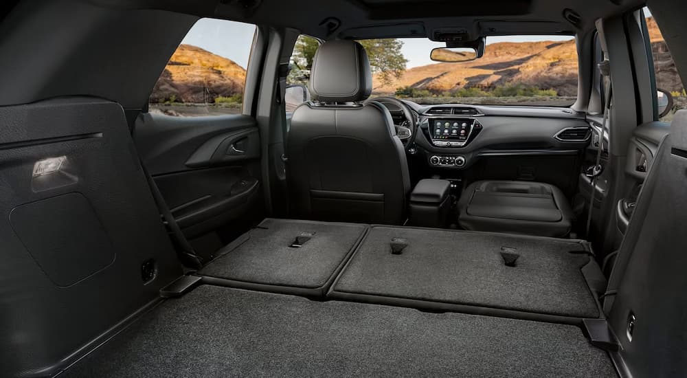 The tremendous cargo space of a 2023 Chevy Trailblazer for sale is shown with the seats folded down.