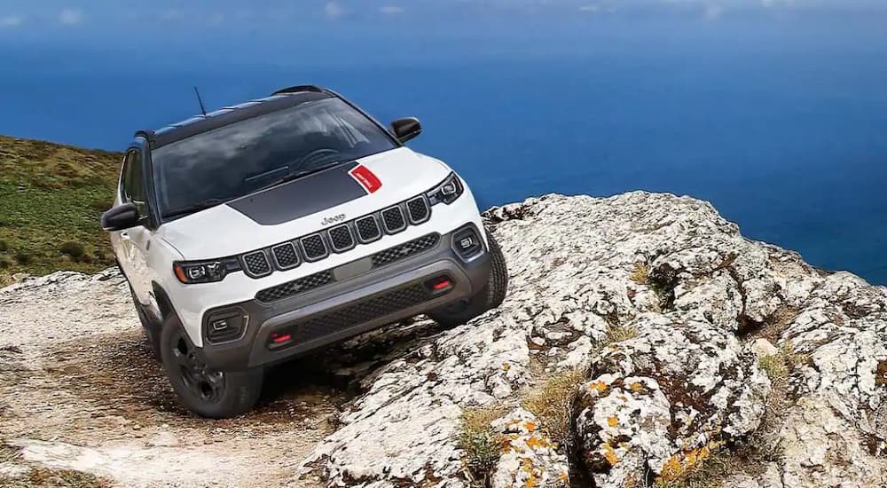 A white 2023 Jeep Compass Trailhawk is shown parked on top of a mountain.