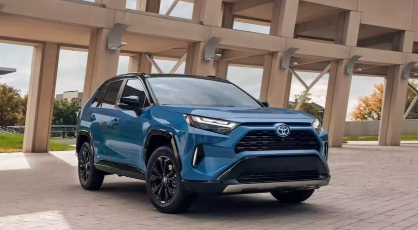 A blue 2023 Toyota RAV4 for sale is shown parked inside of a parking garage.