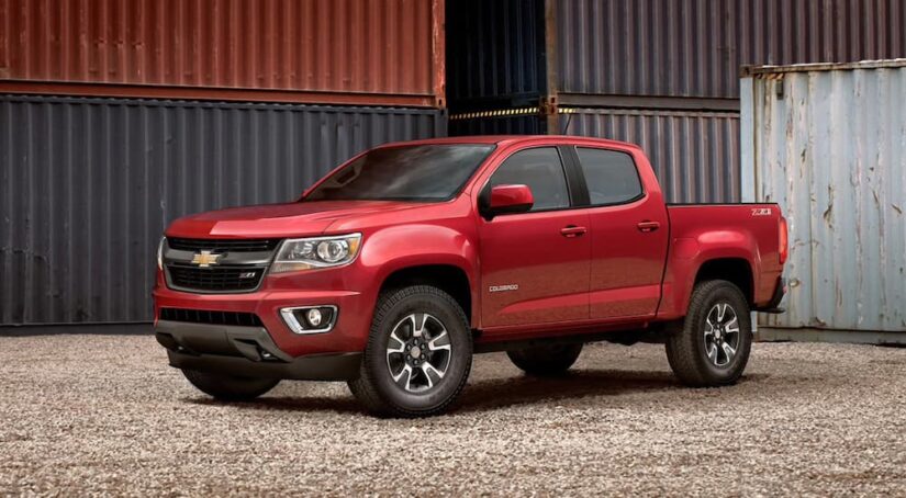 A red 2020 Chevy Colorado is shown parked near shipping containers.