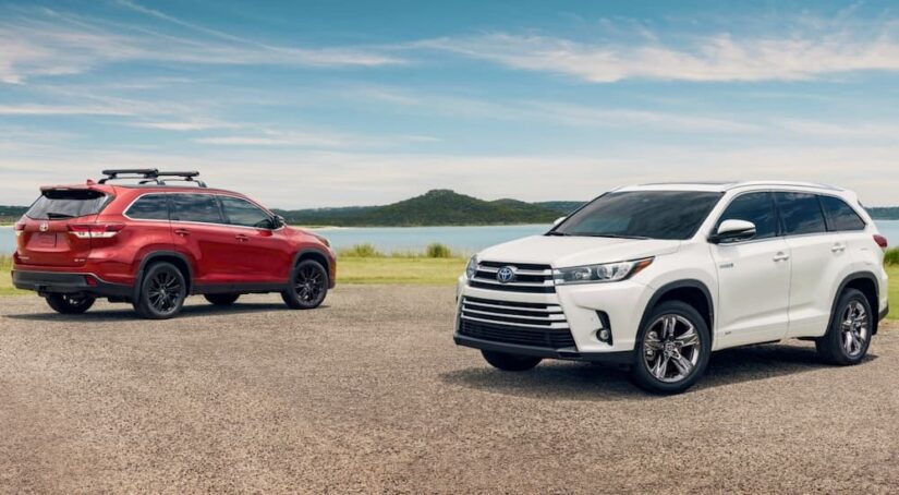 A red and white 2019 Toyota Highlander for sale are shown parked near a lake.
