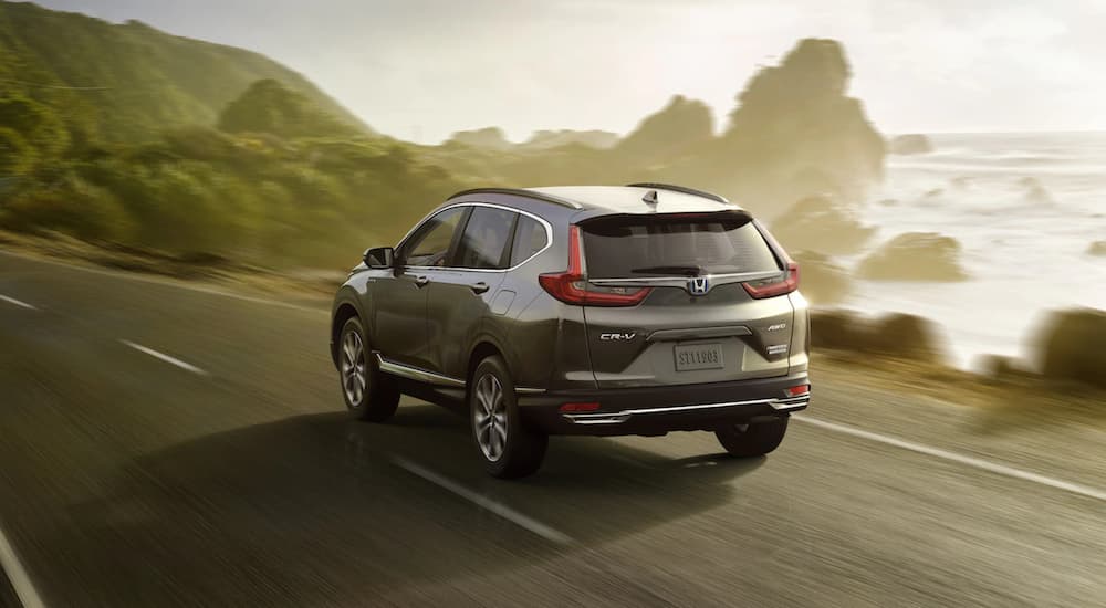 A gray 2021 Honda CR-V is shown driving on a road.