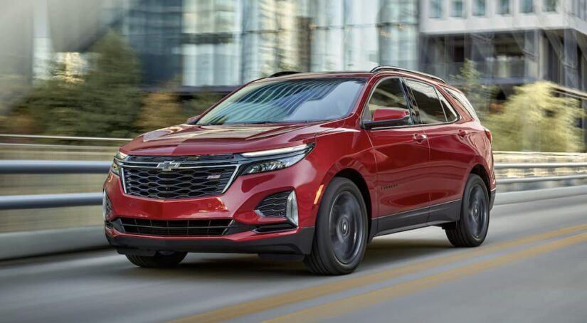 A red 2023 Chevy Equinox RS is shown driving on a road after winning a 2023 Chevy Equinox and the 2023 Honda CR-V comparison.