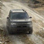 A gray 2023 Ford Bronco Sport Badlands is shown driving off-road.
