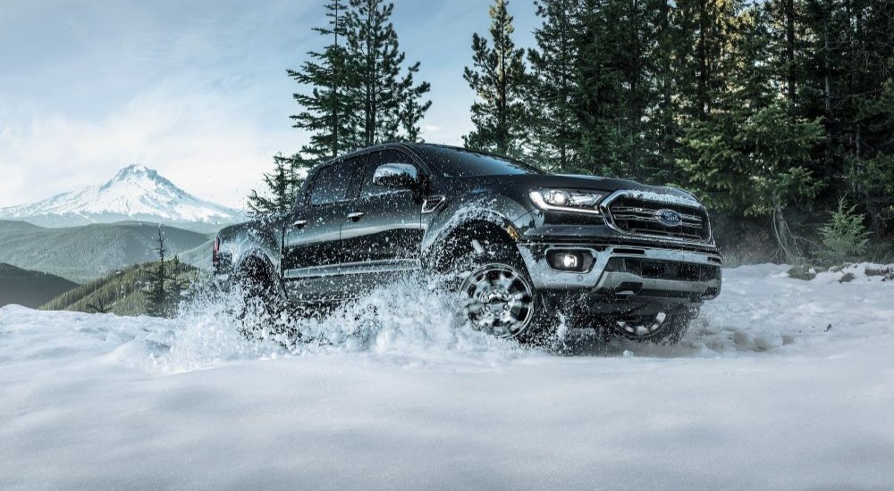 A black 2023 Ford Ranger FX4 is shown driving on the snow.