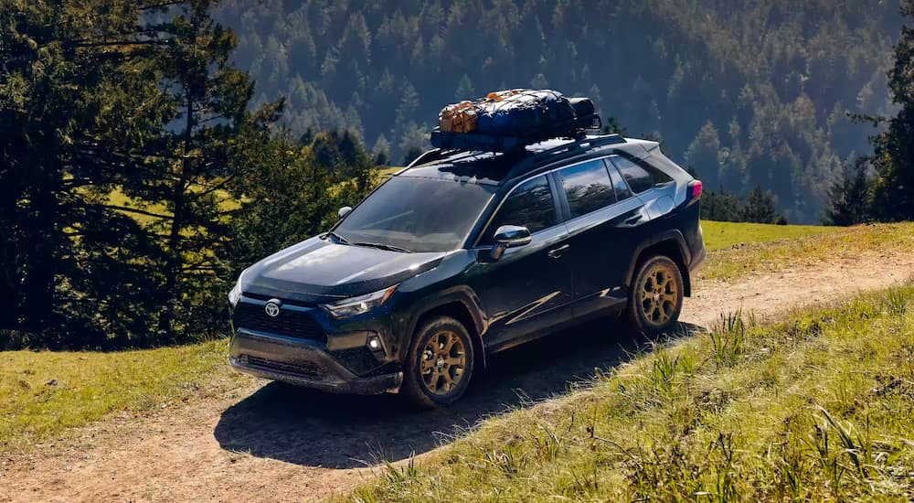 A blue 2023 Toyota RAV4 is shown driving off-road.
